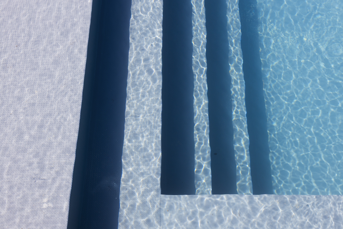 Una piscina esterna lussuosa con acqua blu chiara e natura