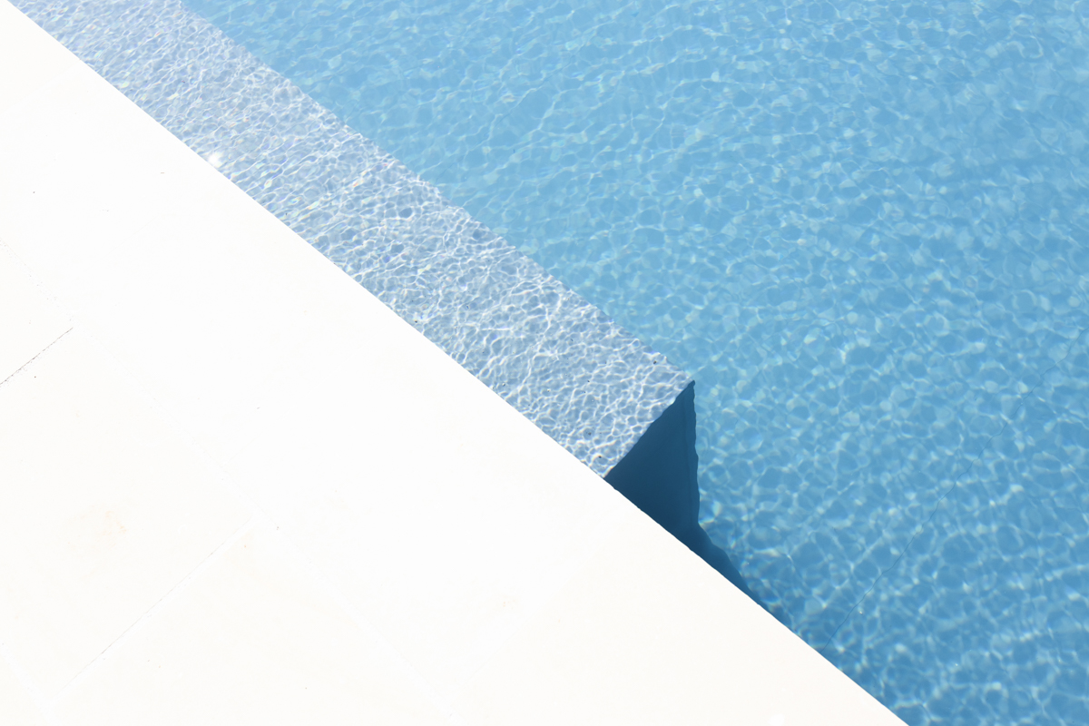 Una piscina al tramonto, con una calda luce dorata che si riflette sull'acqua.